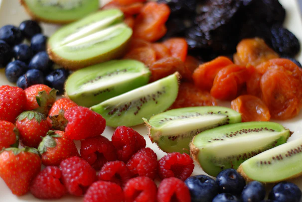 a white plate topped with sliced kiwis and berries