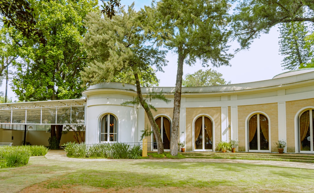 a large white building with arched windows in a park