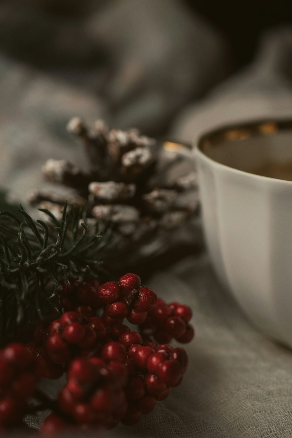 a cup of coffee and a pine cone on a table