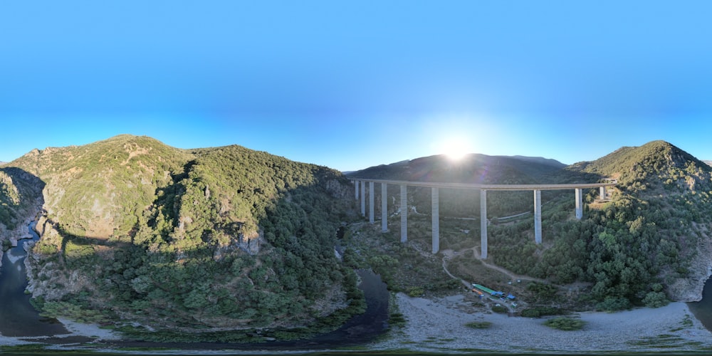 a large bridge over a river surrounded by mountains