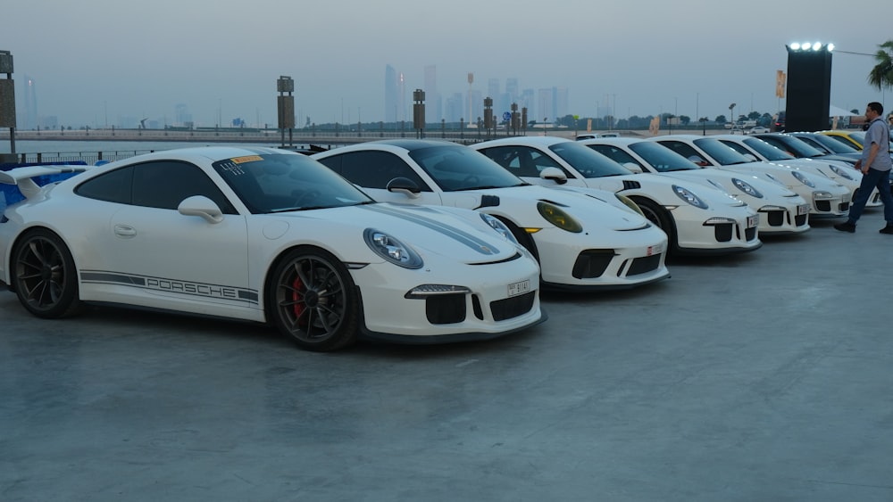 a row of white porsches parked next to each other