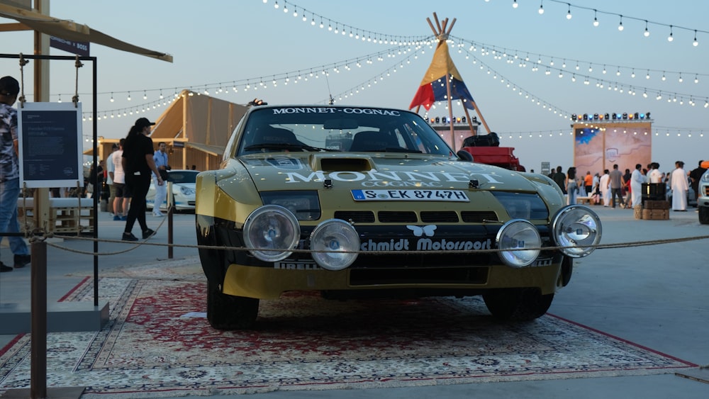 a car is parked on a rug in front of a tent