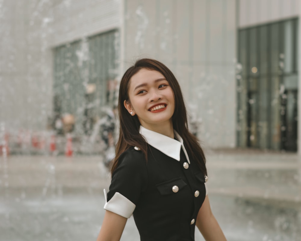 a woman standing in front of a water fountain