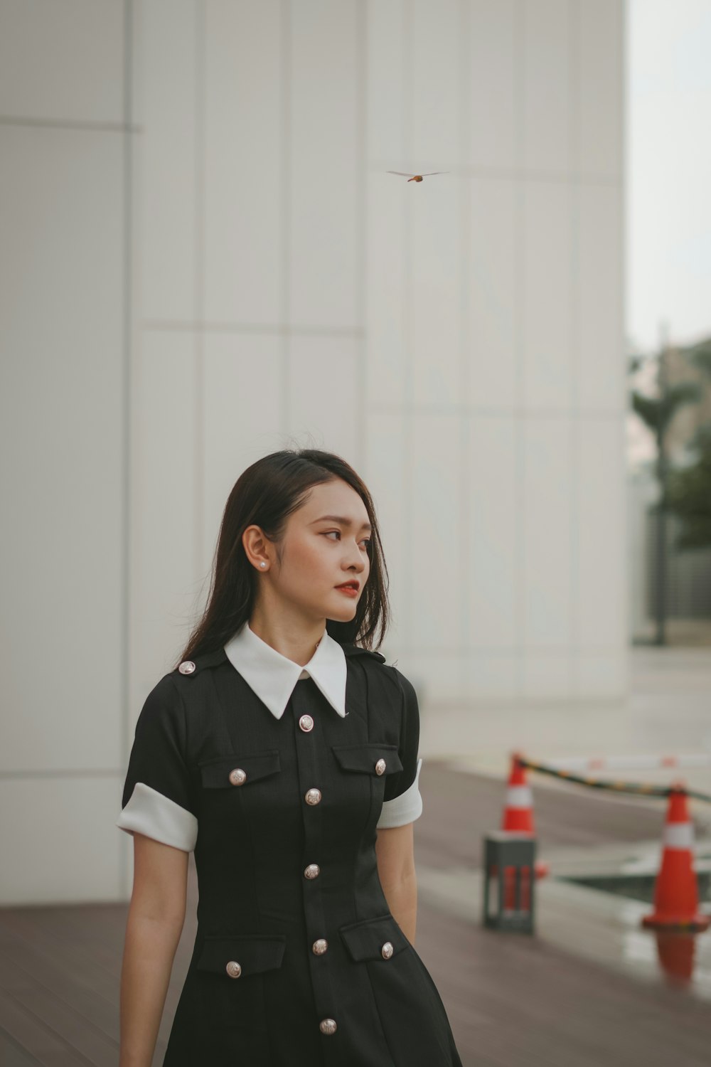 a woman in a black and white dress standing in front of a building