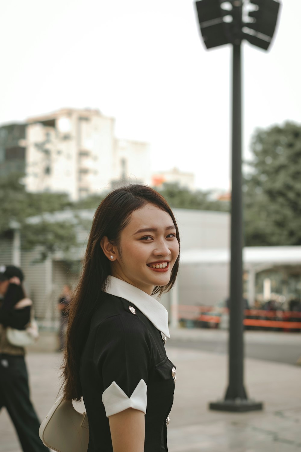 a woman standing in front of a street light