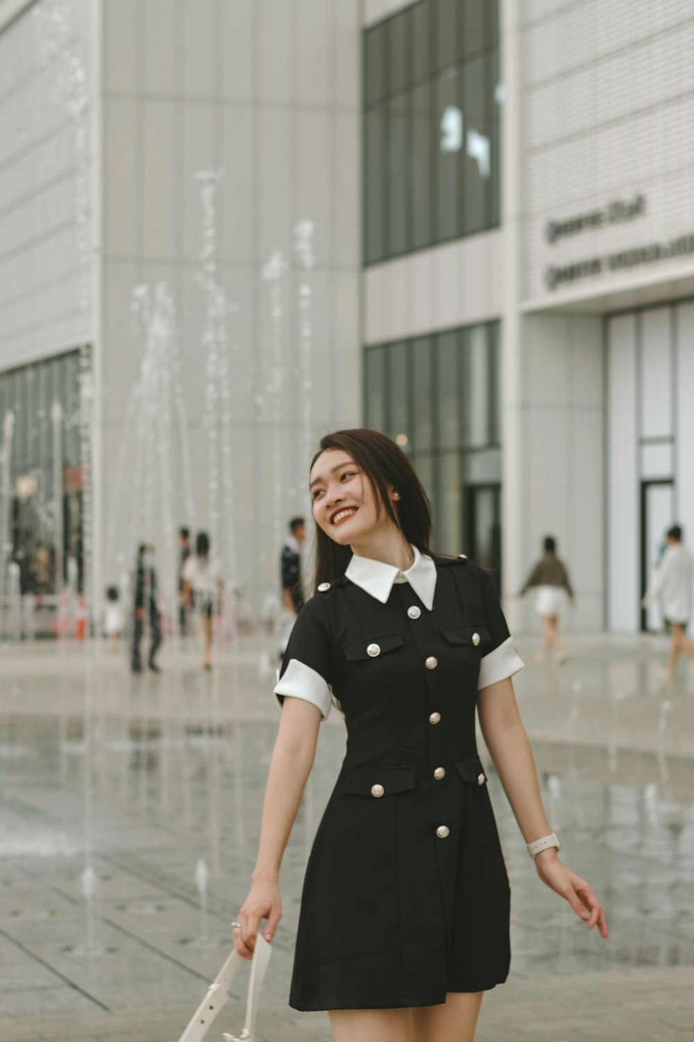 a woman in a short black dress holding a white umbrella