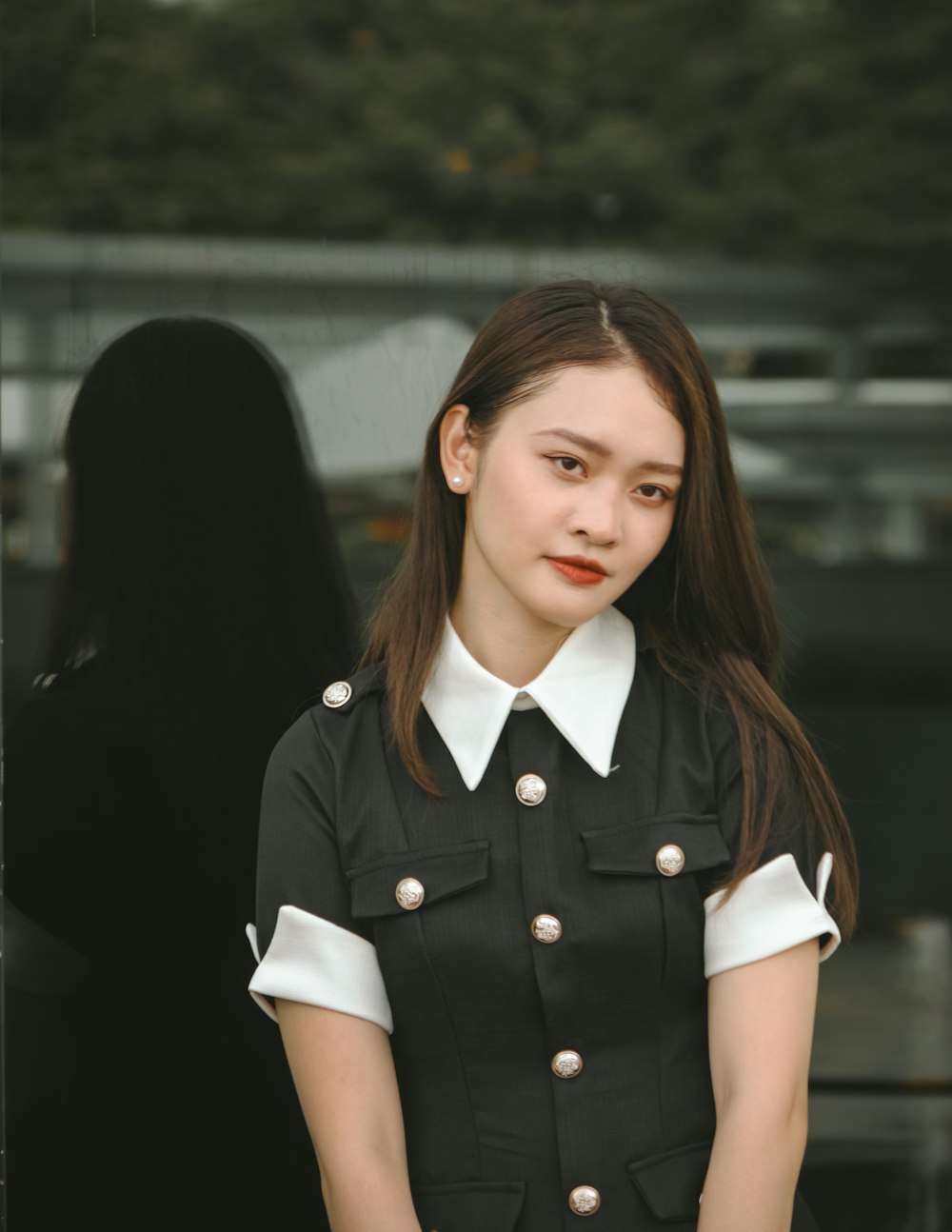 a woman in a black and white uniform standing in front of a building