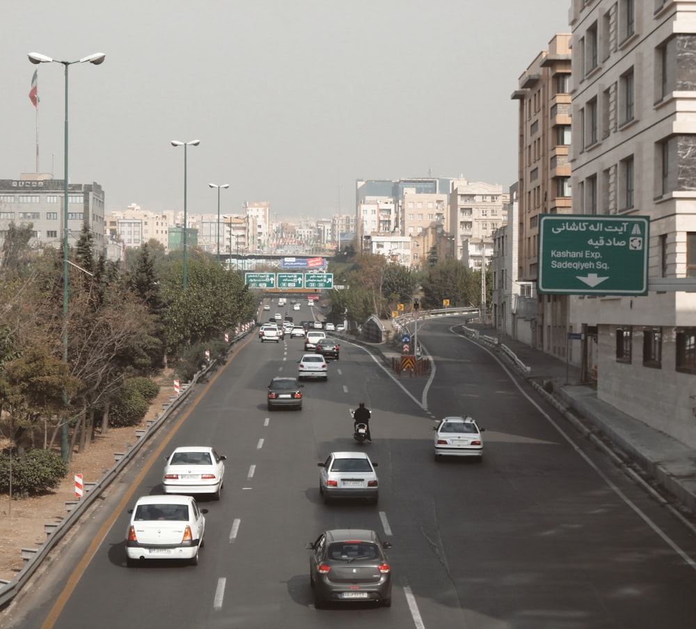 a city street filled with lots of traffic next to tall buildings