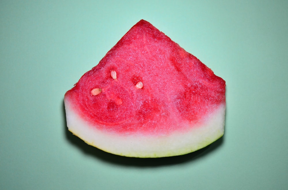a slice of watermelon on a green surface
