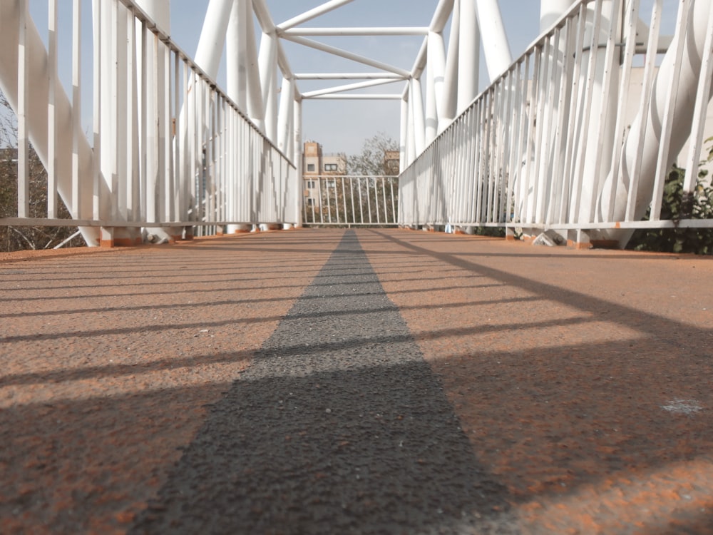a white bridge with a shadow on the ground