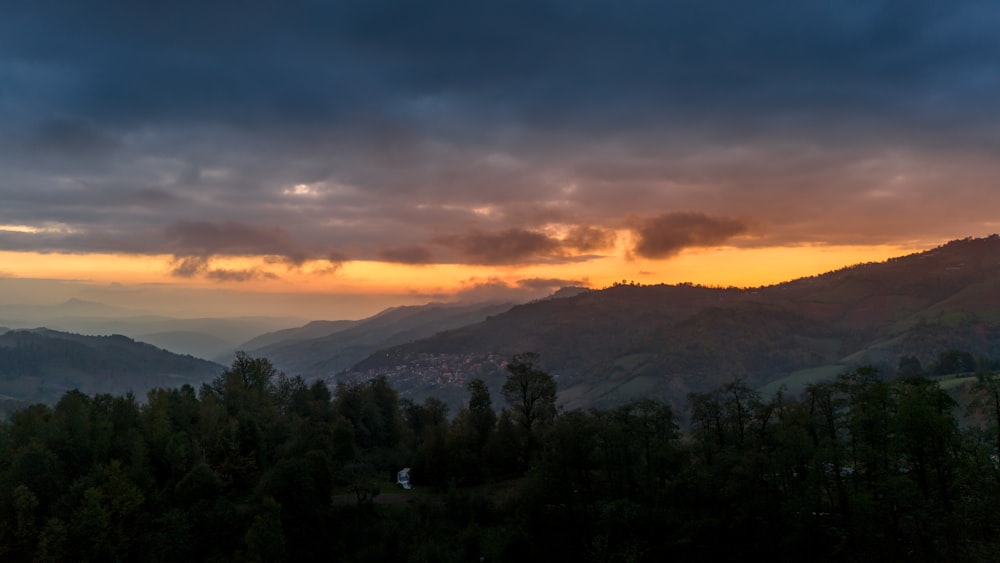 the sun is setting over a mountain range