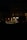 Nighttime image of a veterinary emergency clinic with a brightly lit entrance. There is a red traffic light in front of the building, and a white vehicle with 'VET' written on it is parked nearby. The scene appears calm with minimal activity.