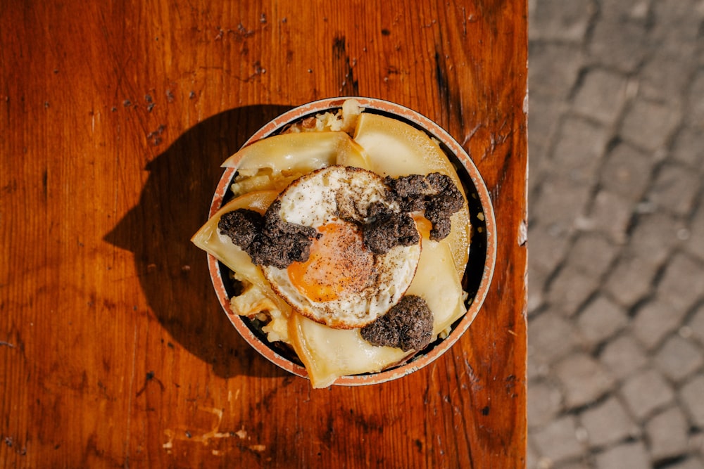 a bowl of food sitting on top of a wooden table