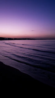 A tranquil sunset over a calm ocean horizon with soft pastel colors