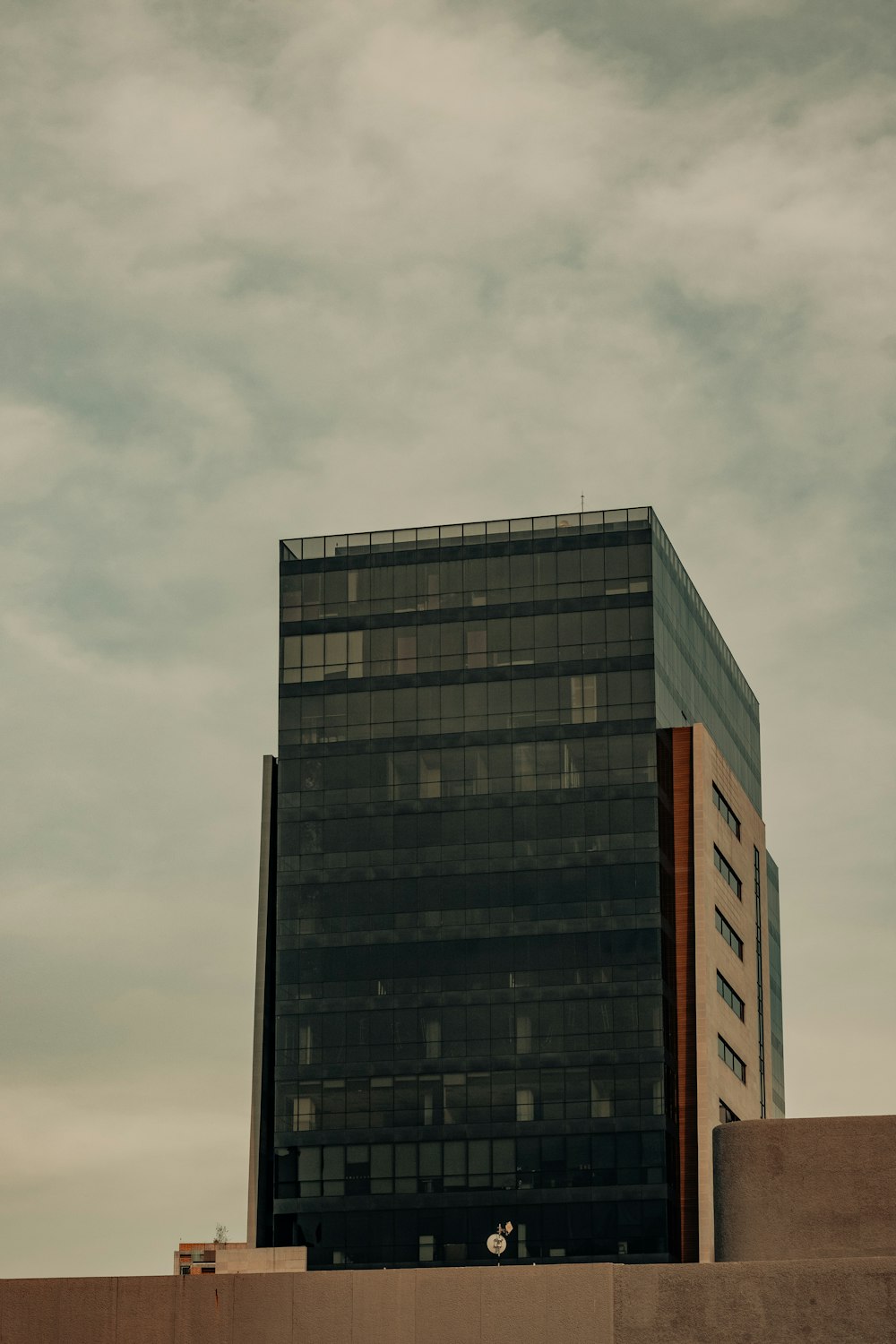 a tall black building sitting next to a tall building
