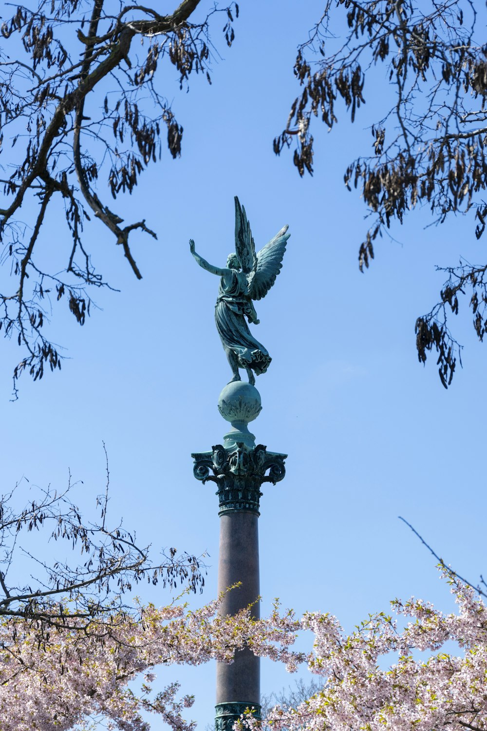 Una estatua en la parte superior de un poste de luz en un parque