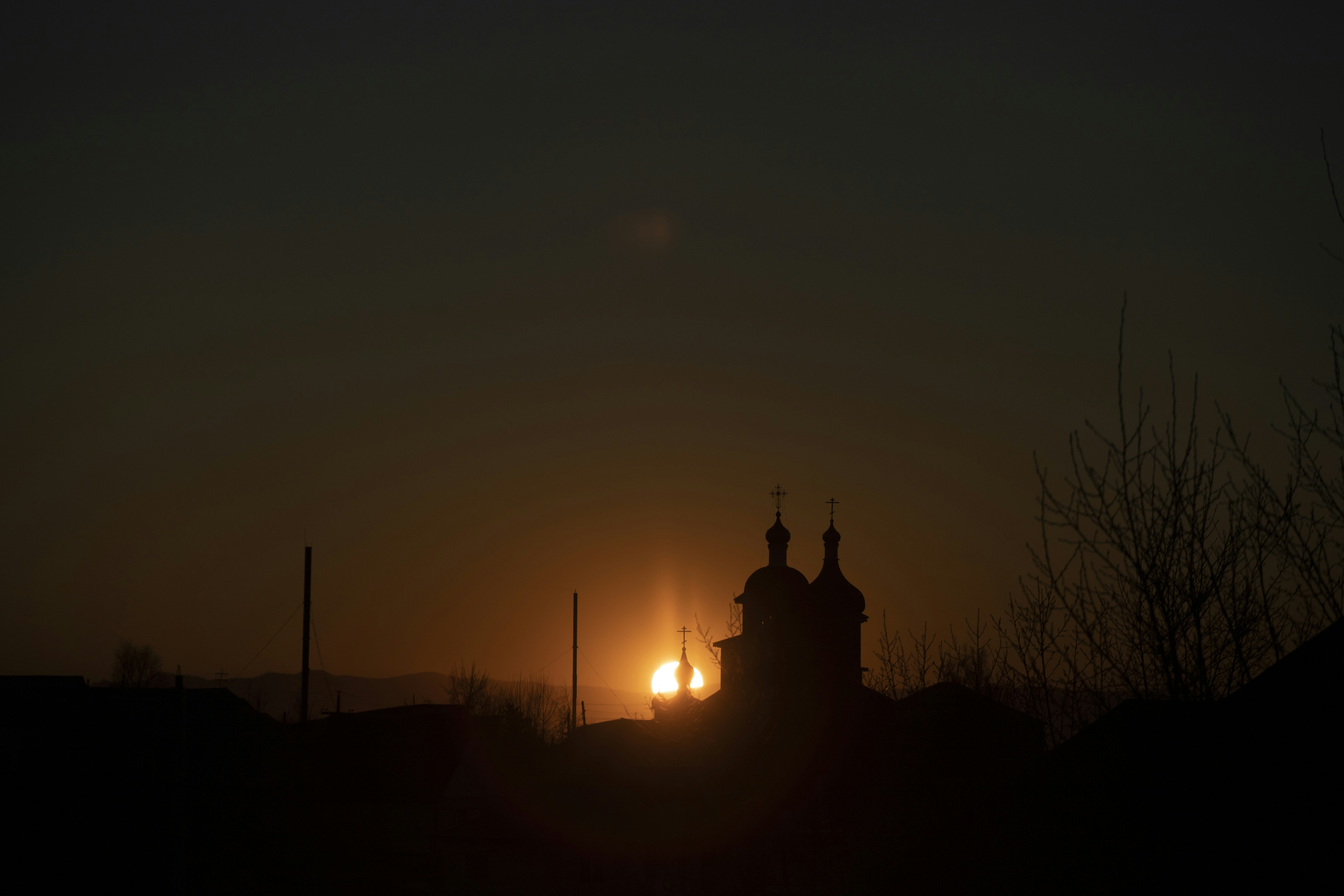 the sun is setting behind a church tower, Sunset in Ulan-Ude
