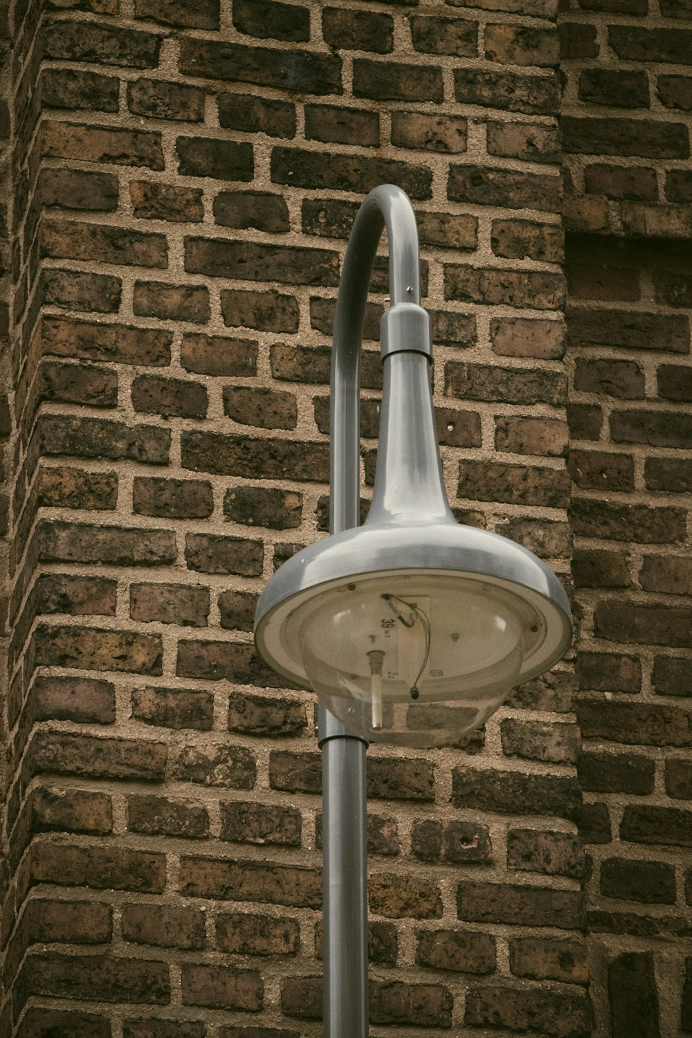 a street light in front of a brick wall