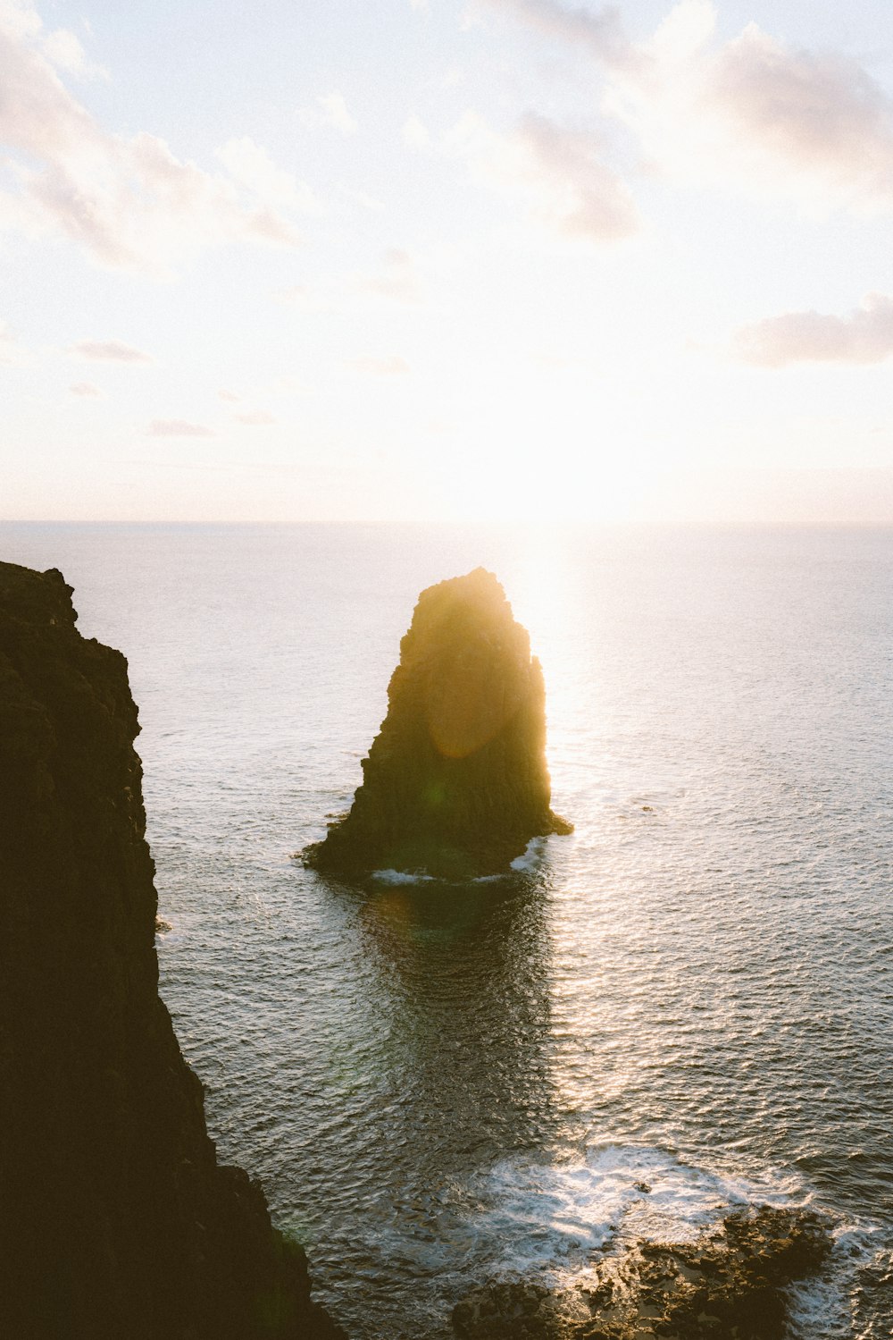 a large rock sticking out of the ocean