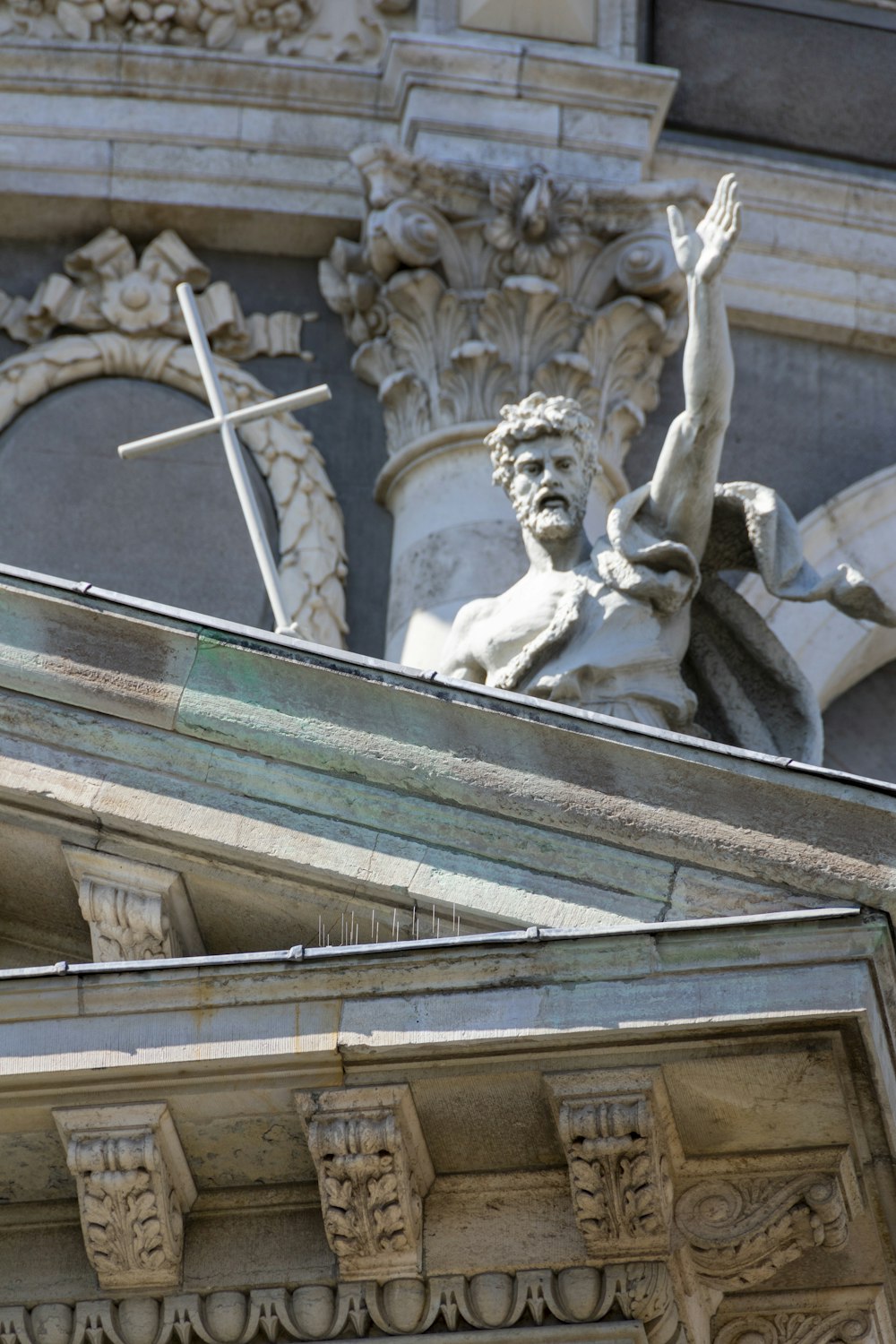 a statue of a man holding a cross on top of a building