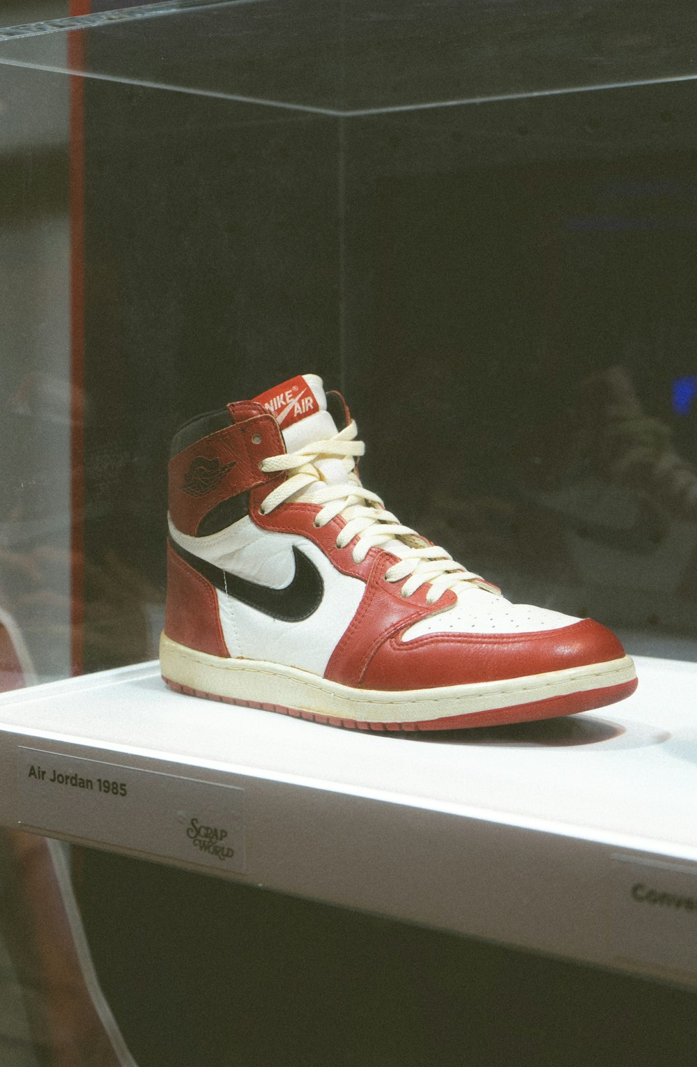 a pair of red and white sneakers on display