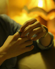 Hands carefully polishing a vintage gold ring under soft lighting.