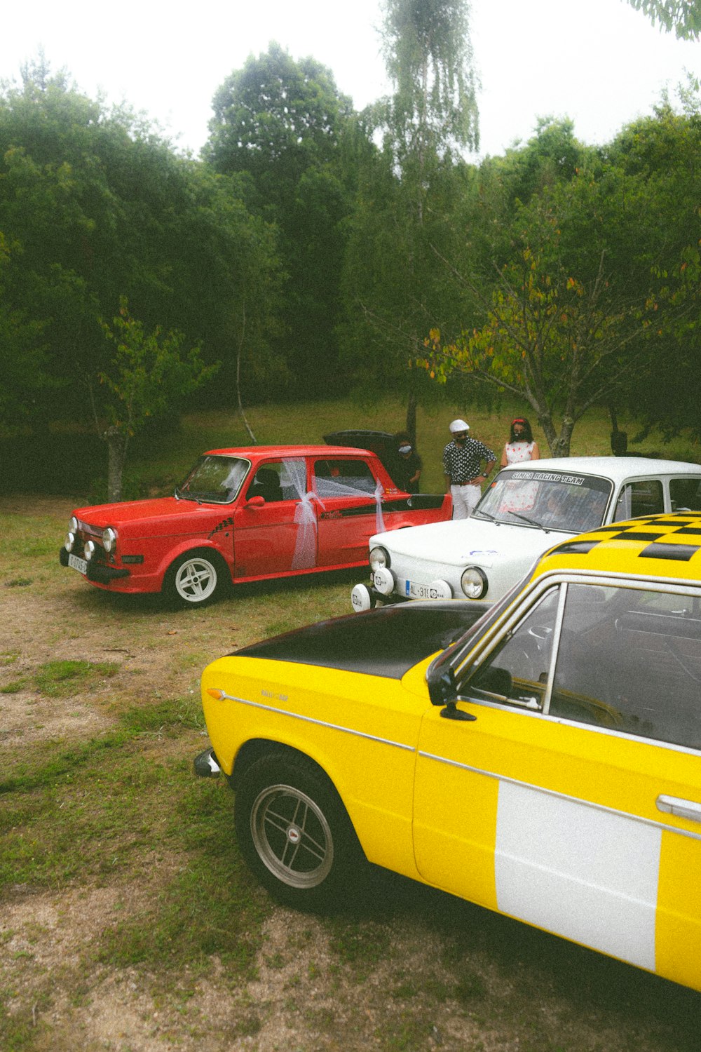 a group of cars parked next to each other in a field