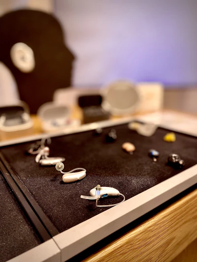Close-up of modern hearing aids displayed on a soft surface with warm lighting