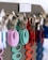 A close-up of multiple keychains hanging on a display rack. The keychains are circular with an oval cutout in the center, coming in various colors including teal, purple, red, and blue. The keychains are attached to metal rings, and they appear to be organized by color.