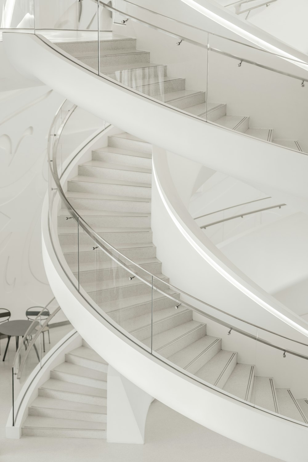 a spiral staircase in a building with a table and chairs