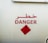 Large bold red text written in both Arabic and English against a light background, indicating a warning with the word 'DANGER'. Below is a red diamond-shaped sign with a symbol of a flame and the words 'INFLAMMABLE GAS 2.1'.