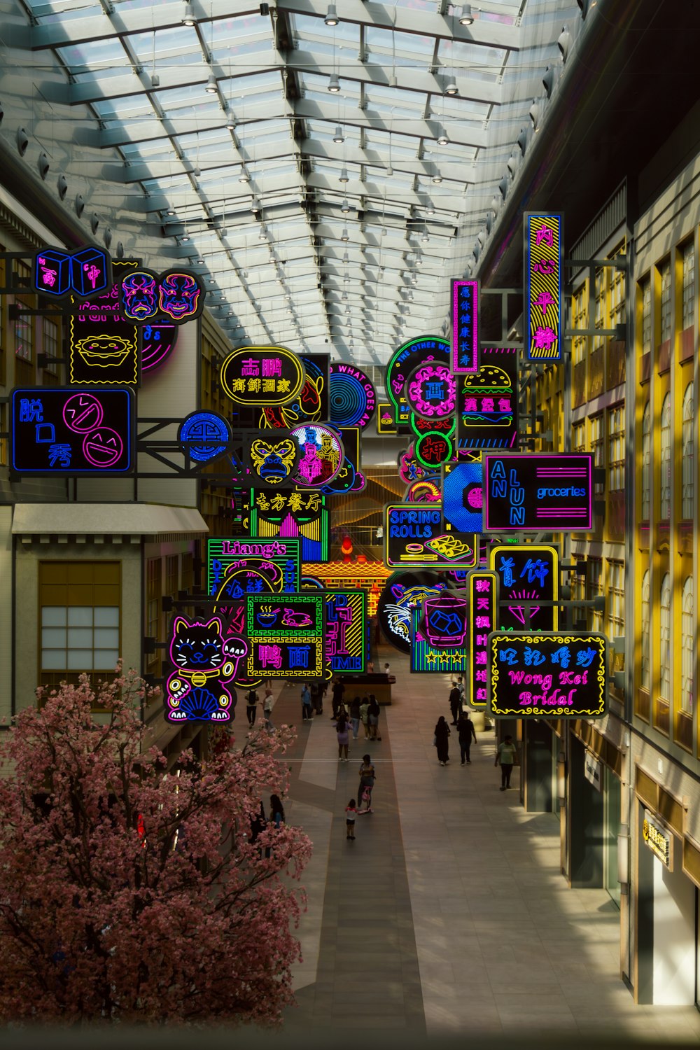 a group of people walking down a walkway under a glass ceiling