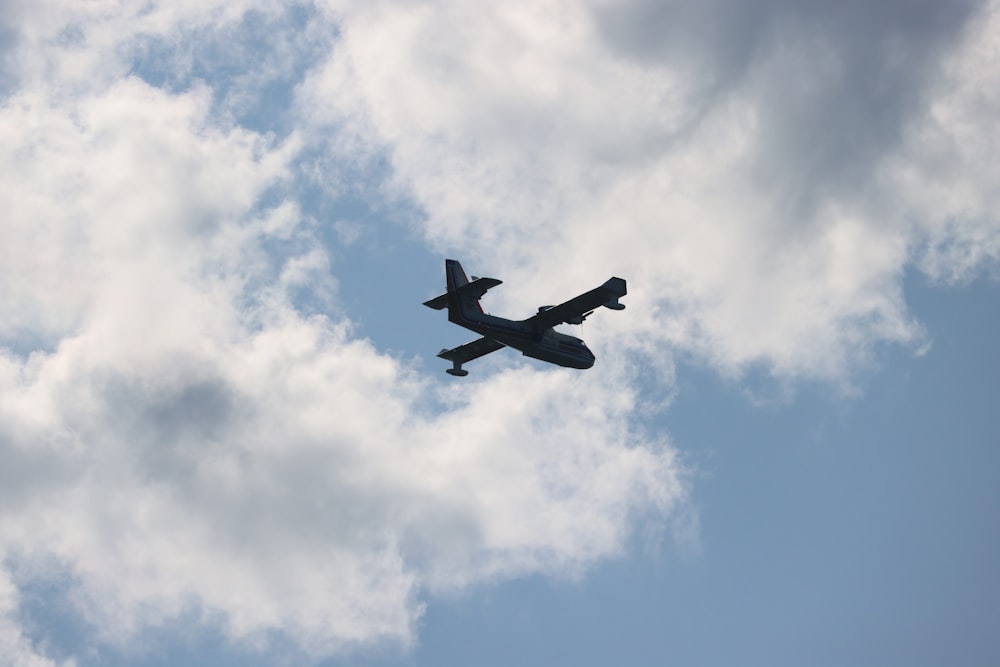 an airplane is flying through the cloudy sky