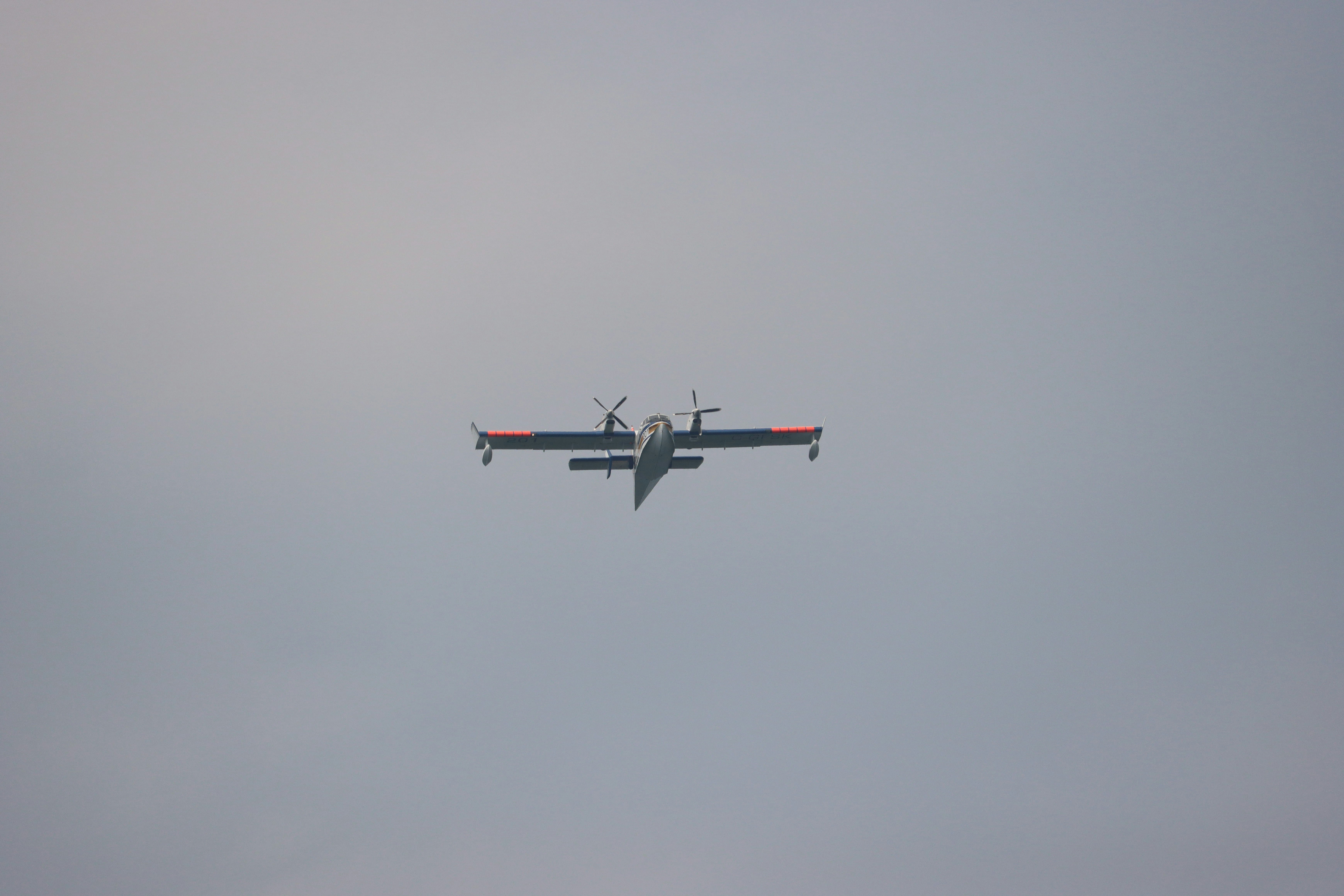 a small airplane flying through a cloudy sky, 