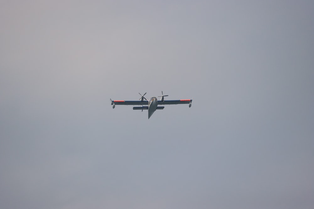 a small airplane flying through a cloudy sky