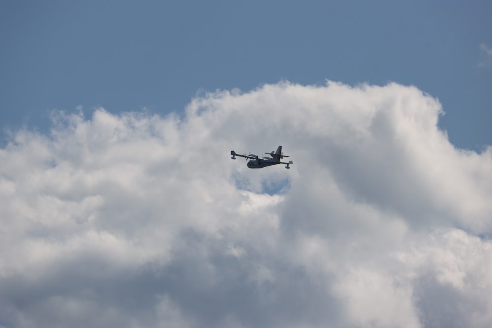 a plane flying through a cloudy blue sky