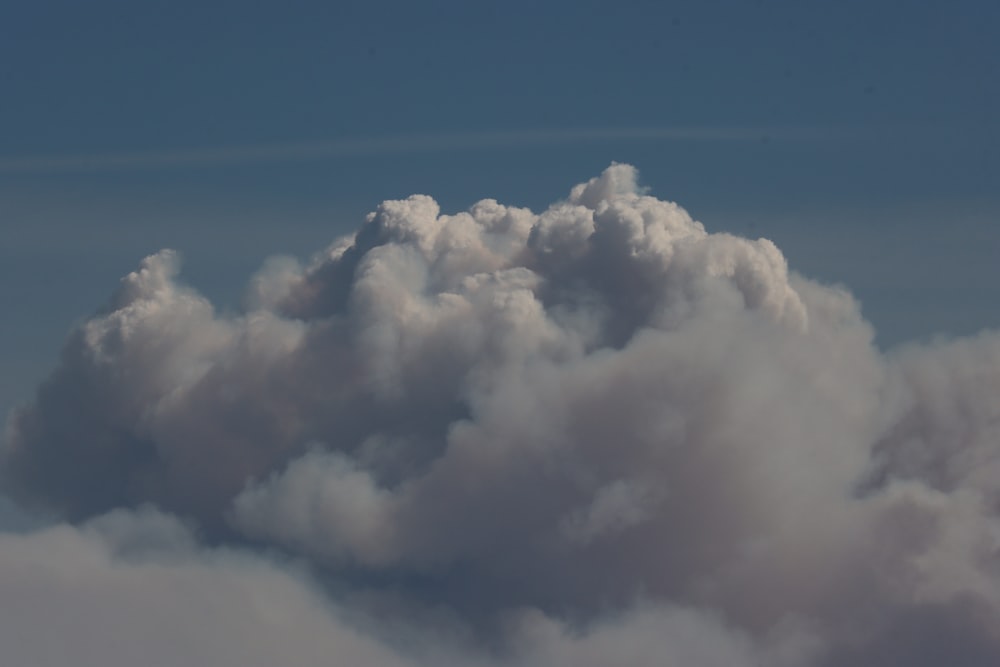 a plane flying in the sky with a lot of clouds