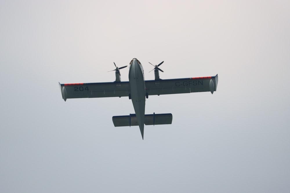 a small airplane flying through a gray sky