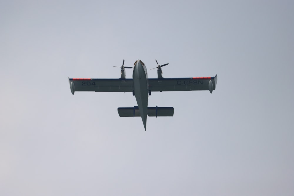 a small airplane flying through a gray sky