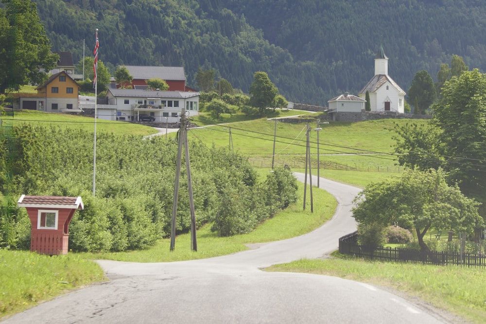 a rural road with a small house on the side of it