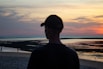 a man standing on top of a beach next to the ocean