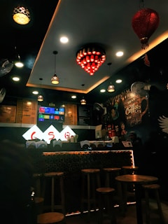 Gold and cream accent lighting highlighting the charcoal walls and the bustling coffee bar at the hayden shop