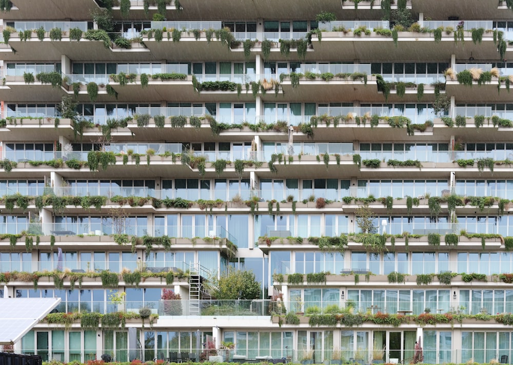 a tall building with a lot of plants growing on the side of it