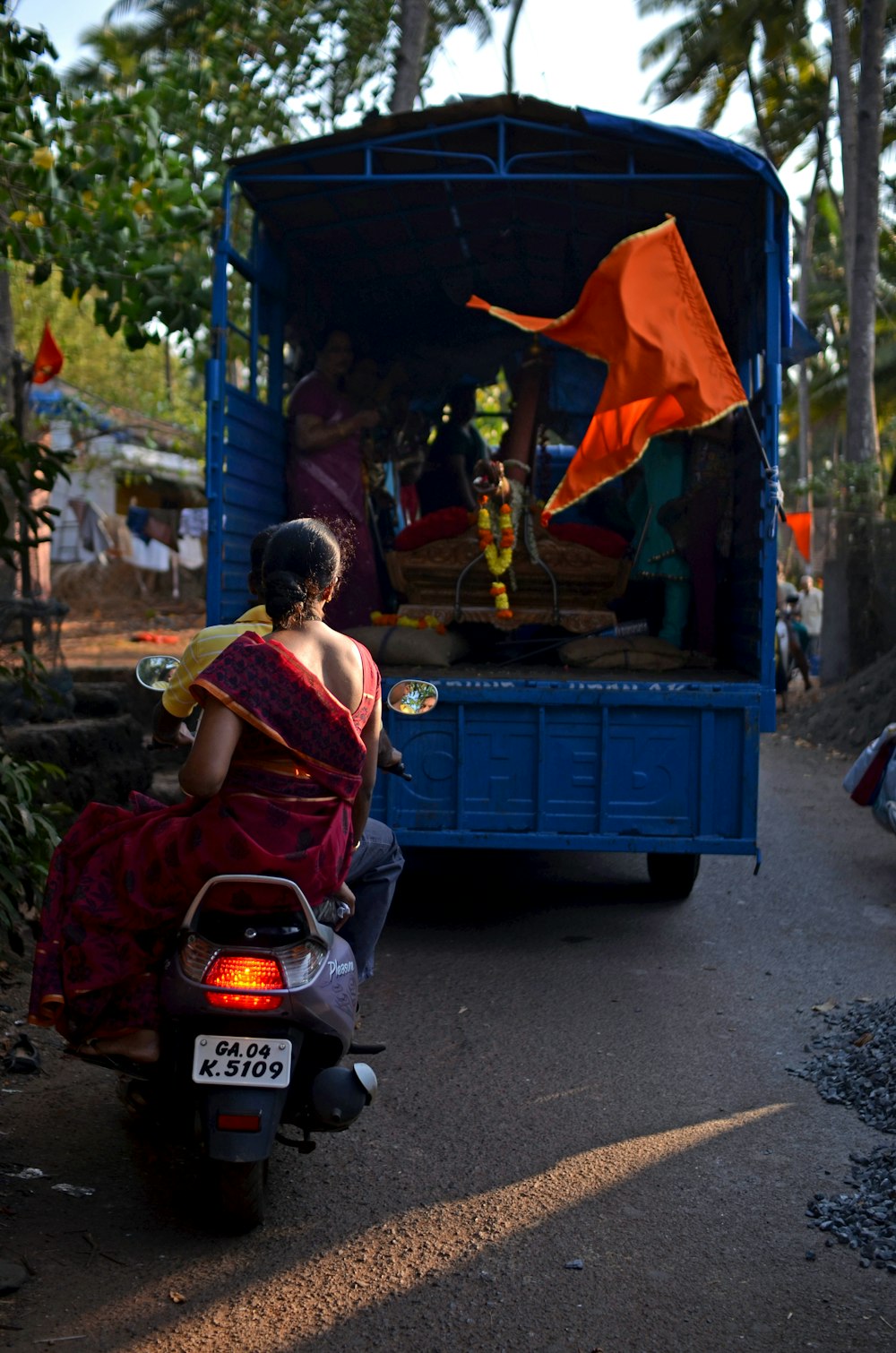 a woman sitting on a scooter in front of a blue truck
