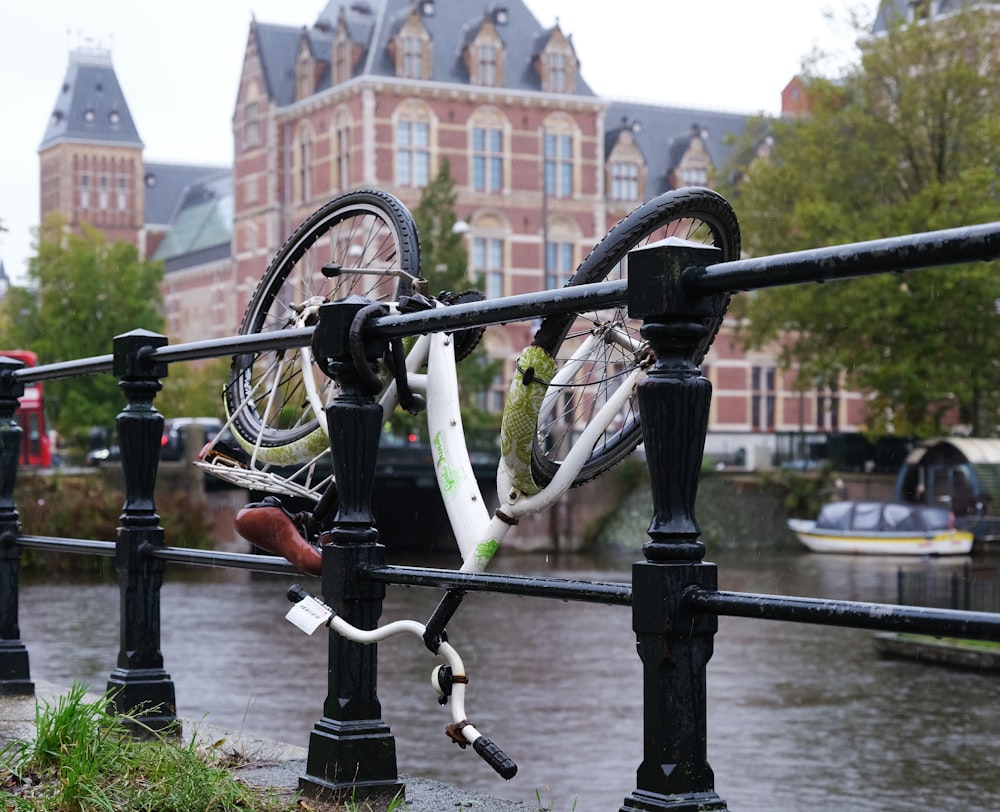 a bicycle locked to a fence next to a body of water