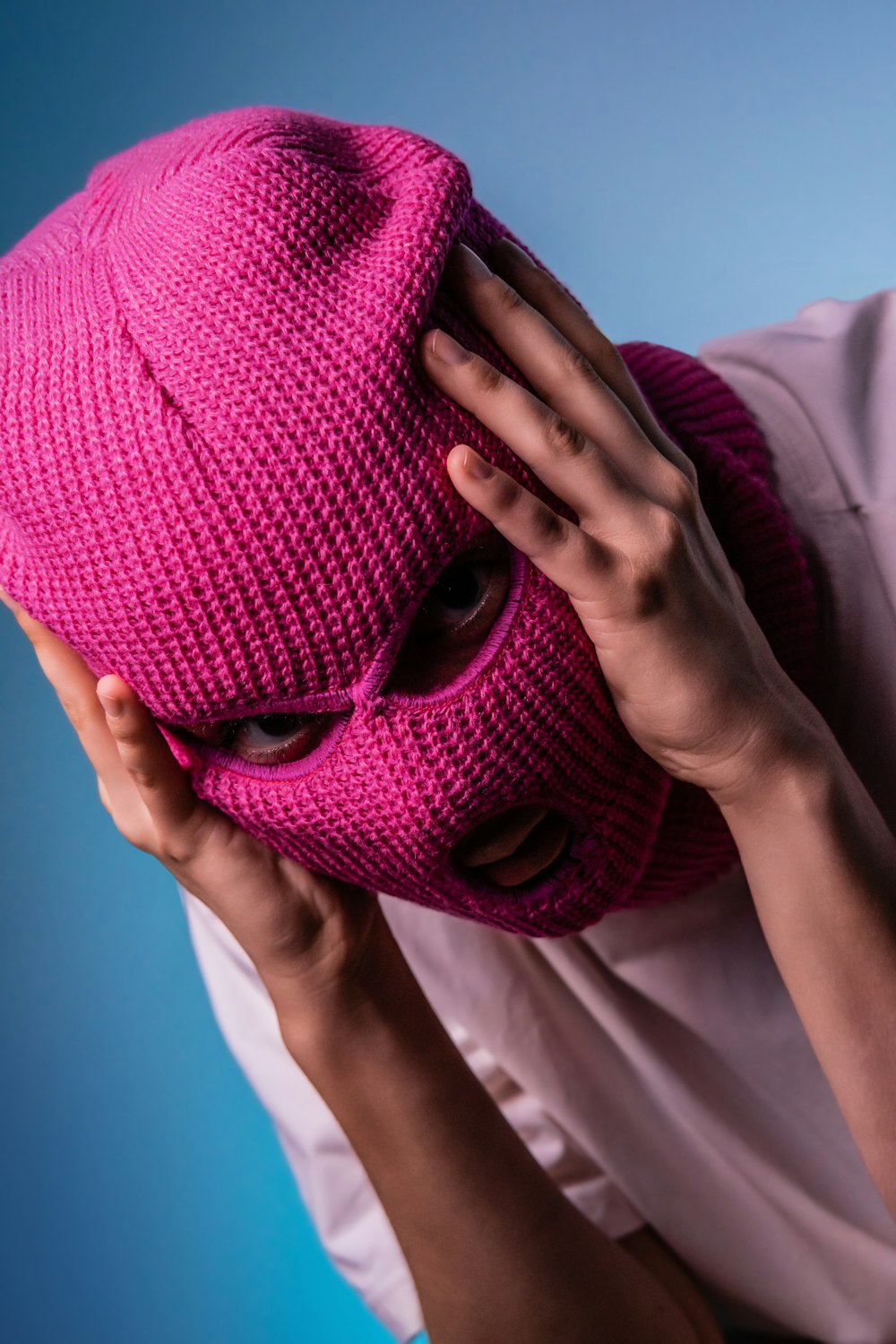 a person covering their face with a pink mask