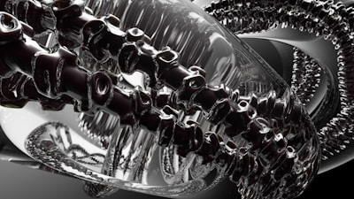 A complex, abstract digital image features intertwined metallic and glass-like structures, resembling a futuristic machine or art installation. Reflective surfaces create a dynamic interplay of light and shadow, with intricate details suggesting a sense of movement or transformation.