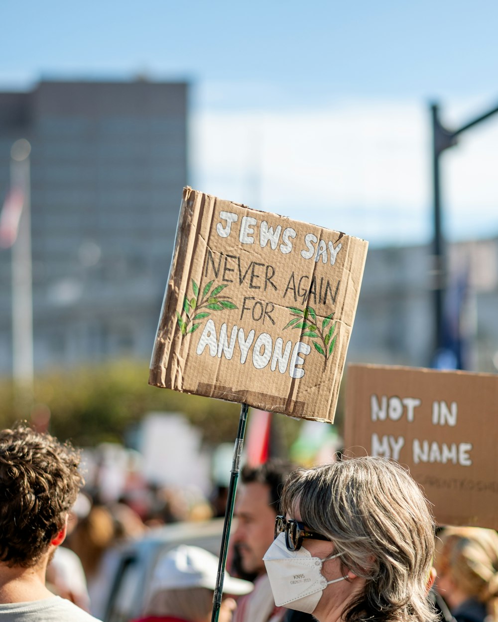 a woman wearing a face mask holding a sign