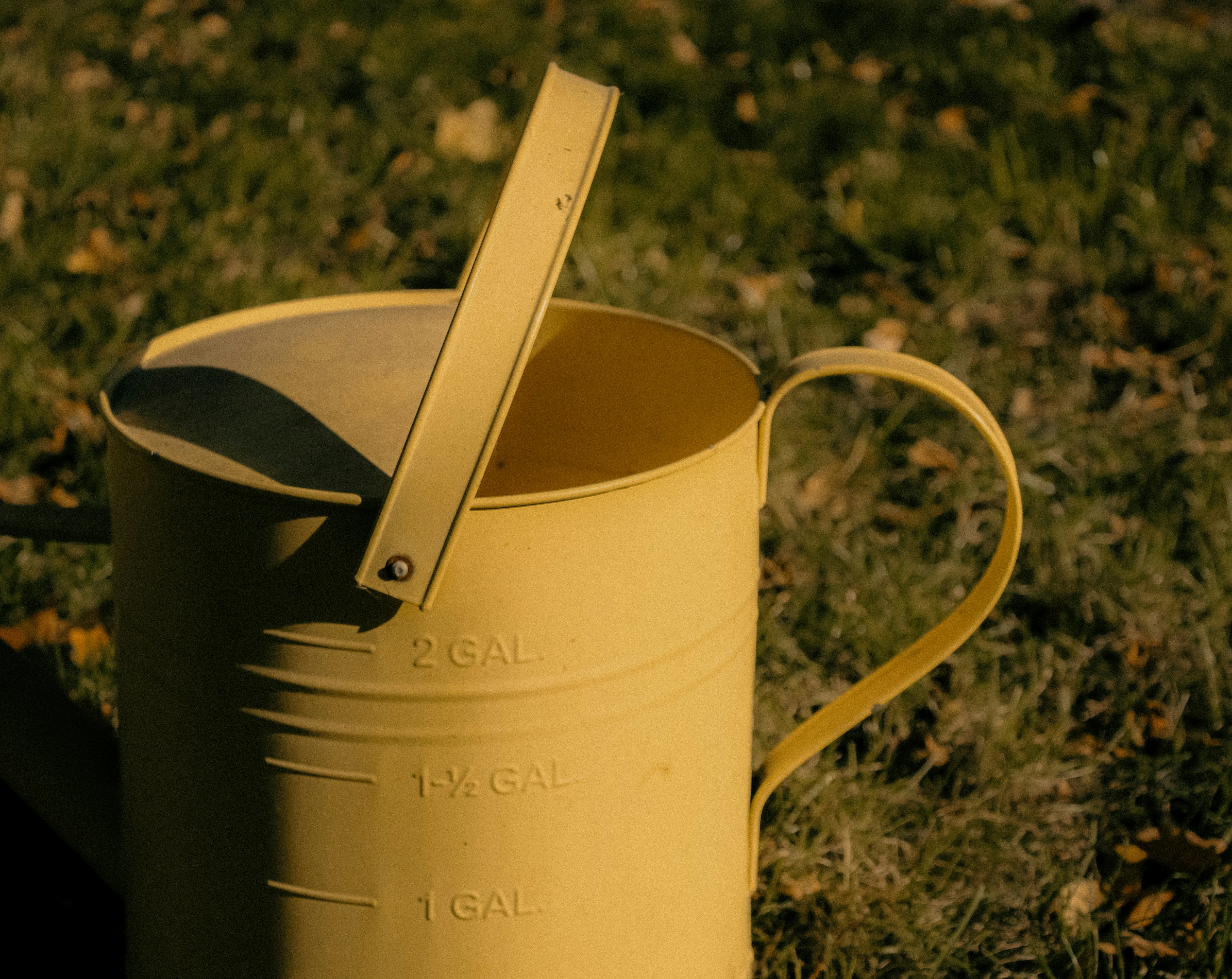 a yellow watering can with a spoon sticking out of it