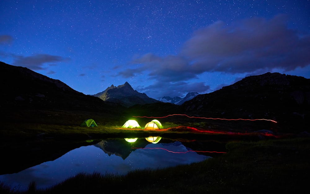 a couple of tents sitting on top of a lush green field